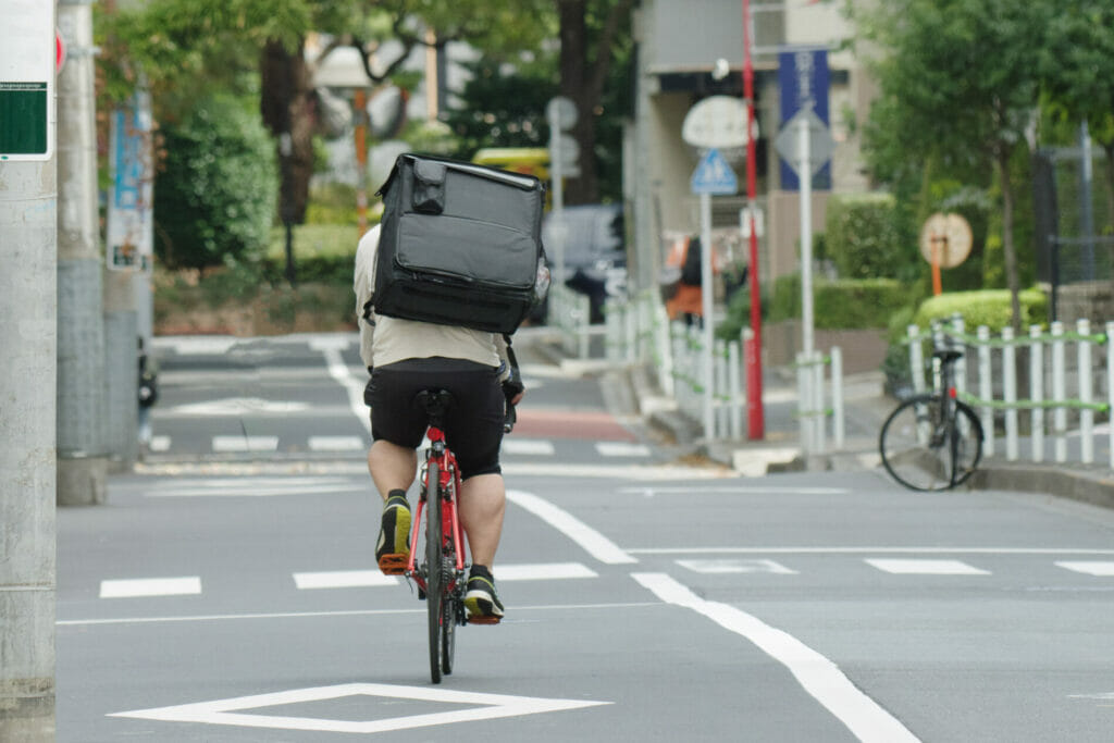 自転車を漕ぐ配達員