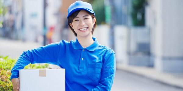 青い服・帽子を着用した笑顔の女性