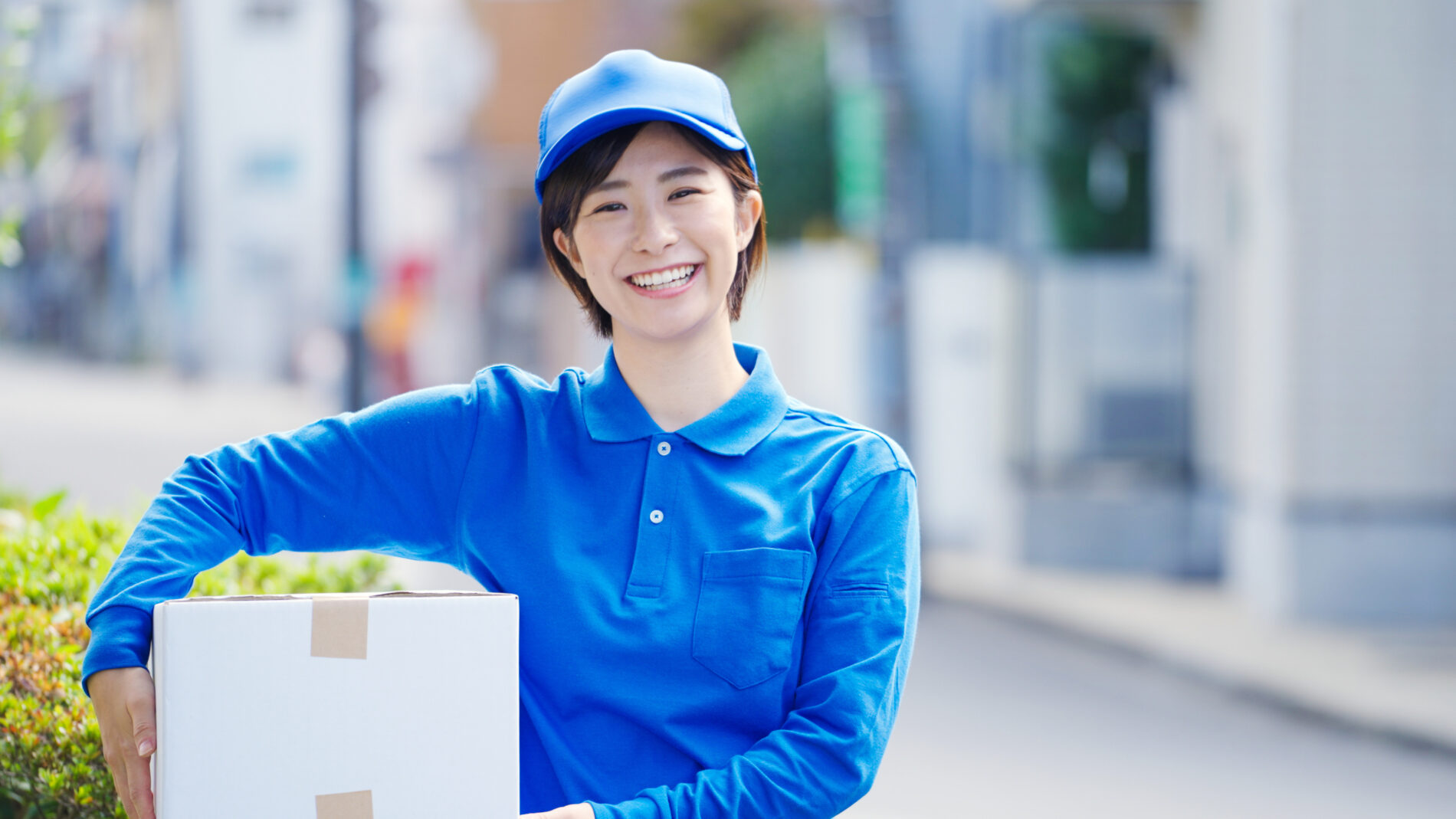 青い服・帽子を着用した笑顔の女性