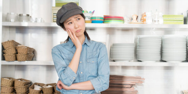 首を傾げている飲食店の女性スタッフ